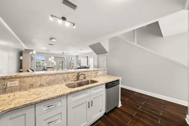 a bathroom with a granite countertop sink a mirror and shower