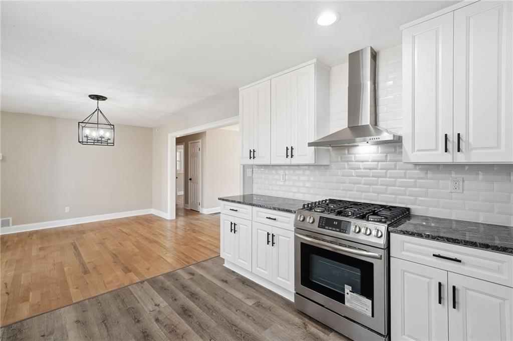 2702 Beecher Drive Austell, GA 30106 - Photo 17 of 27 a kitchen with granite countertop a stove a sink and white cabinets
