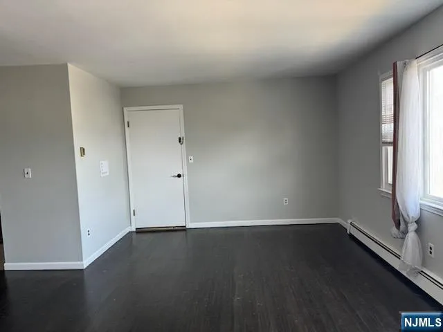 an empty room with wooden floor and window