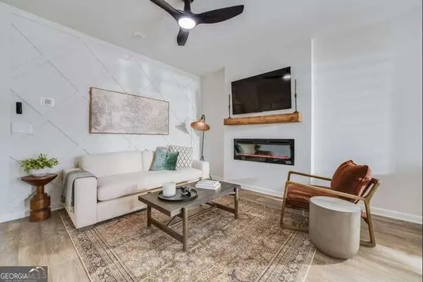 a living room with furniture a flat screen tv and a fireplace