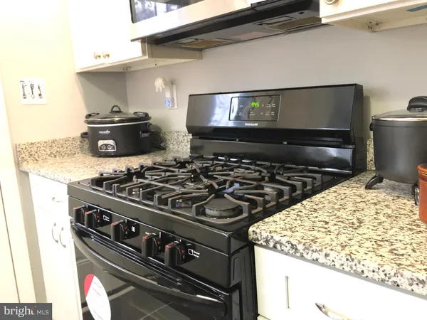 a stove top oven sitting inside of a kitchen
