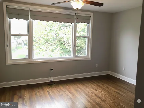 a view of a room with wooden floor and a window
