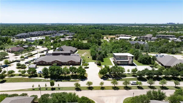 an aerial view of residential houses with outdoor space and lake view