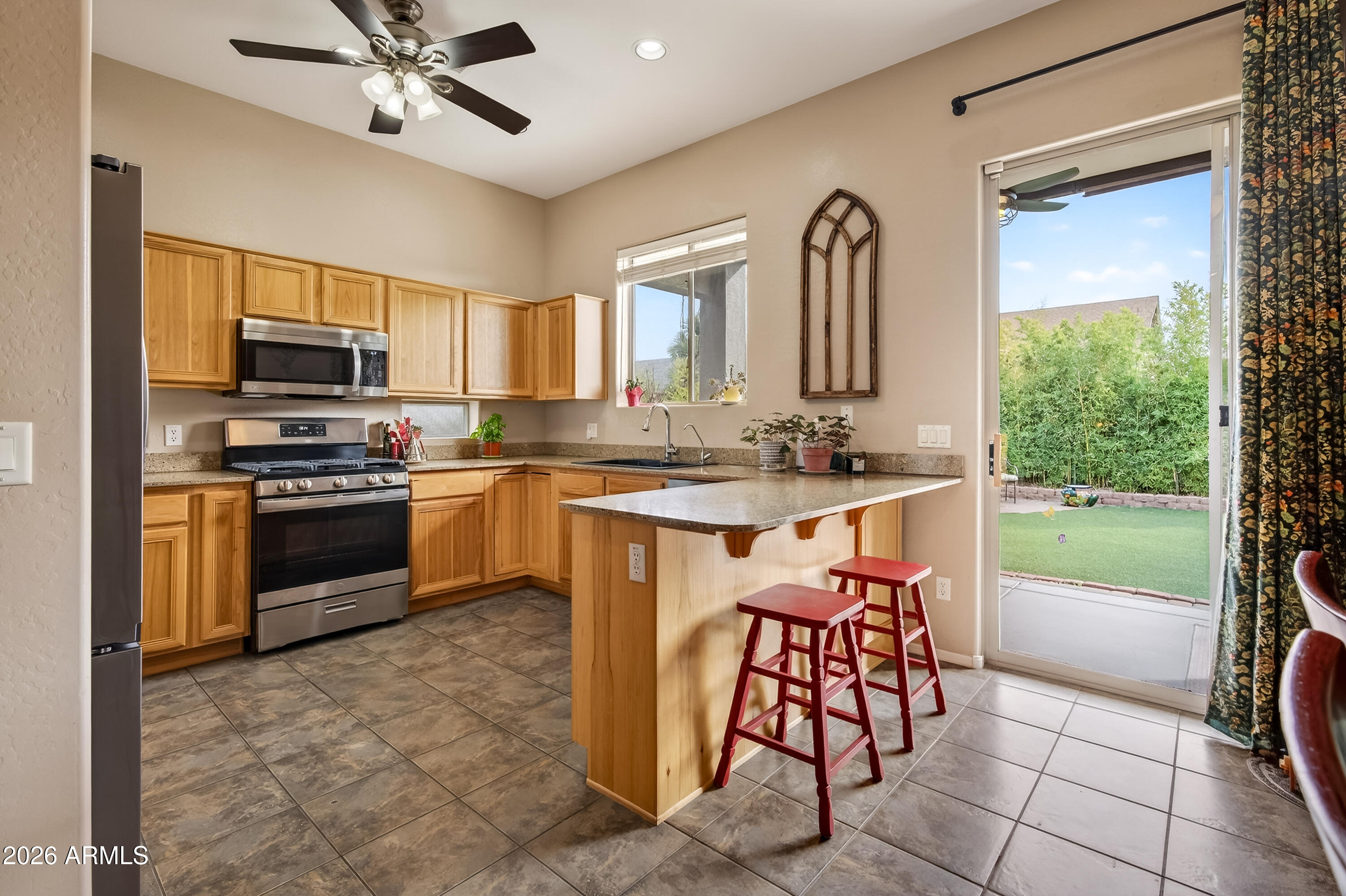 654 South Elk Ridge Drive Camp Verde, AZ 86322 - Photo 12 of 34 a kitchen with stainless steel appliances a stove a sink a microwave a dining table and chairs
