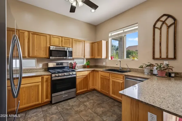 a kitchen with stainless steel appliances granite countertop a refrigerator a stove top oven a sink and dishwasher