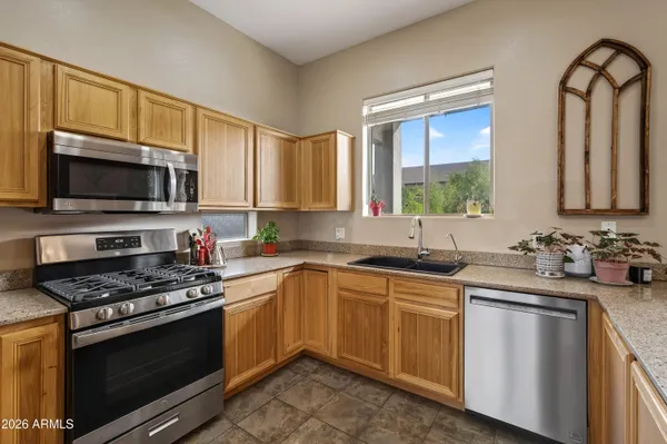 a kitchen with stainless steel appliances a stove sink microwave and cabinets