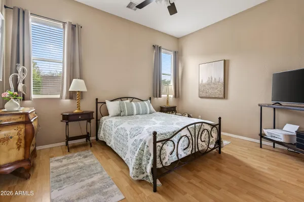 a bedroom with a bed and a flat tv screen on the dresser