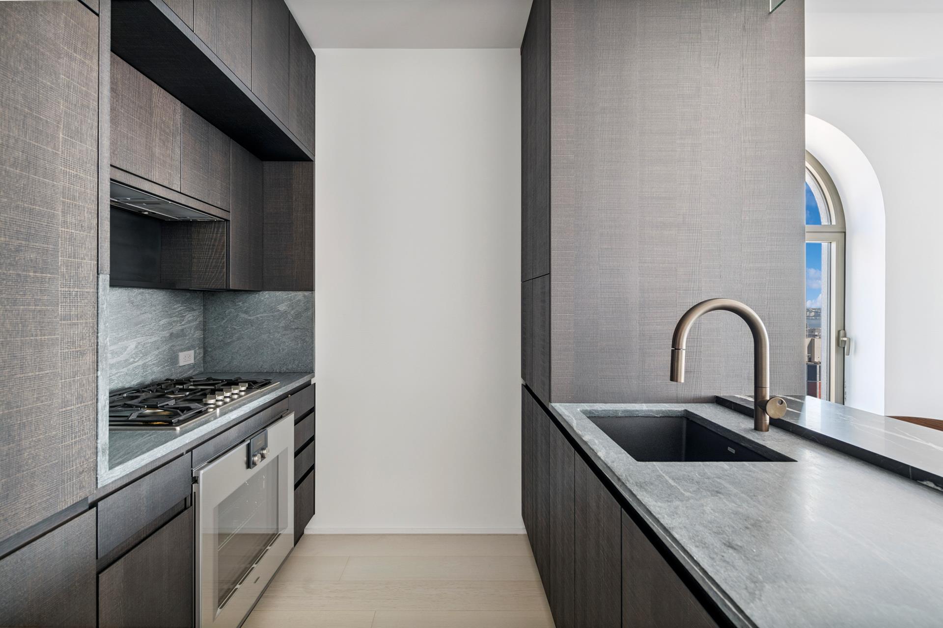 130 William Street, Unit 38A Manhattan, NY 10038 - Photo 4 of 12 a kitchen with granite countertop a stove and a sink