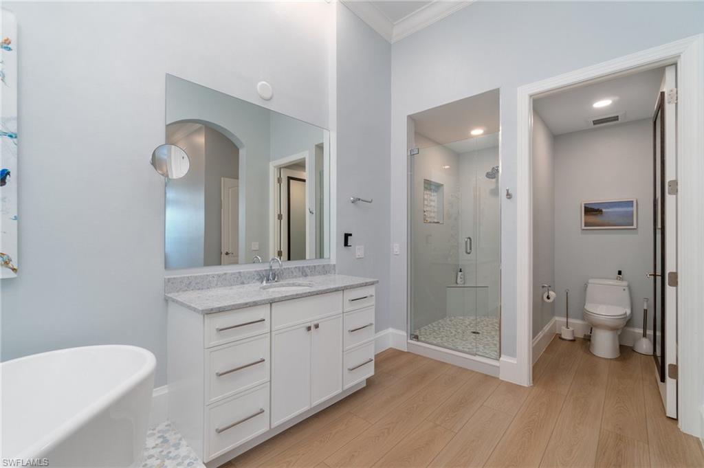 17010 Porta Vecchio Way, Unit 201 Naples, FL 34110 - Photo 13 of 50 a bathroom with a granite countertop toilet a sink and a mirror
