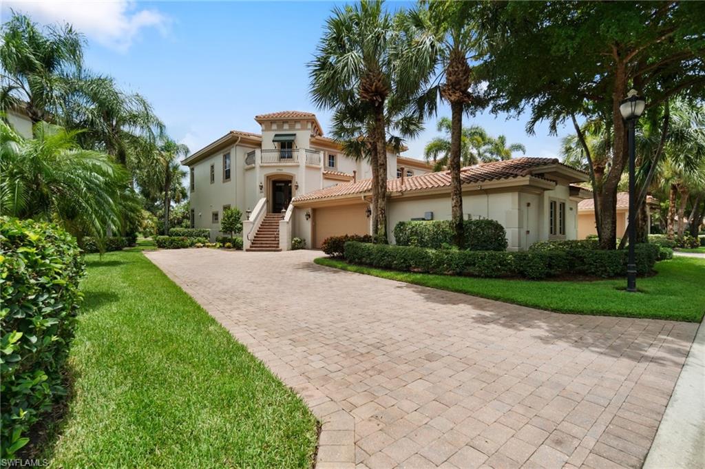 17010 Porta Vecchio Way, Unit 201 Naples, FL 34110 - Photo 24 of 50 a view of a white house next to a yard with big trees