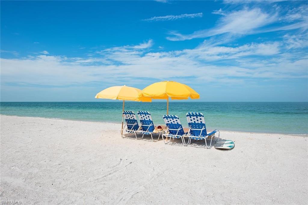 17010 Porta Vecchio Way, Unit 201 Naples, FL 34110 - Photo 49 of 50 a view of a swimming pool with lawn chairs under an umbrella