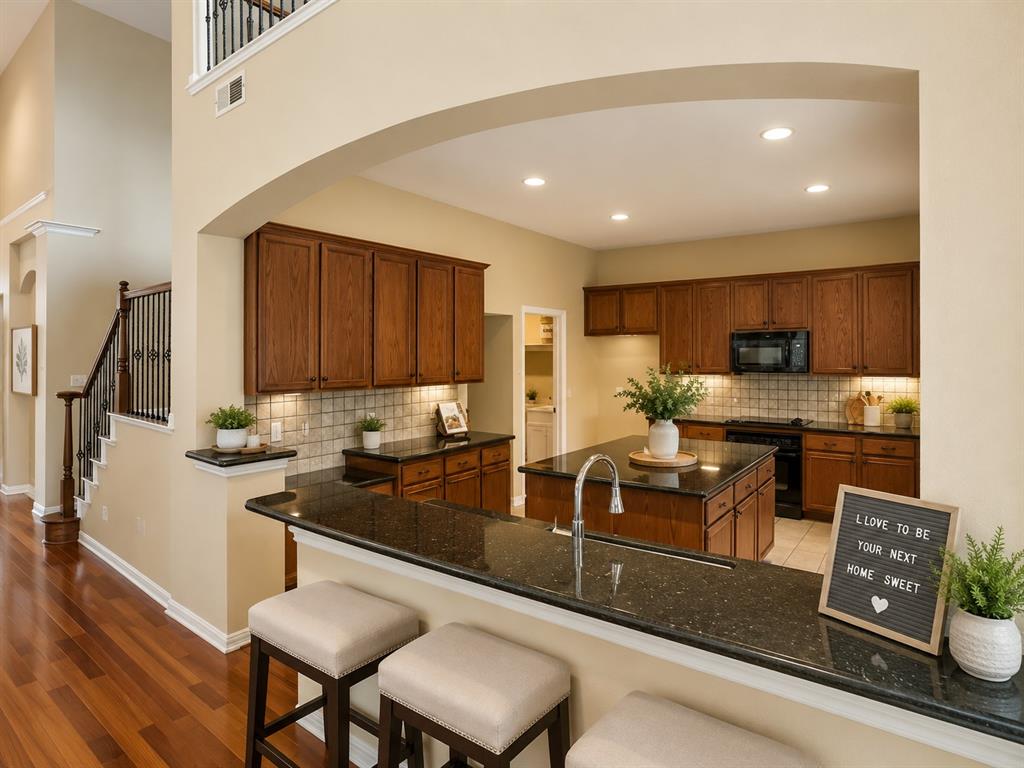 5708 Rickshaw Lane Plano, TX 75094 - Photo 9 of 28 Gourmet kitchen featuring rich wood cabinetry, dark stone countertops, tile backsplash, and recessed lighting
