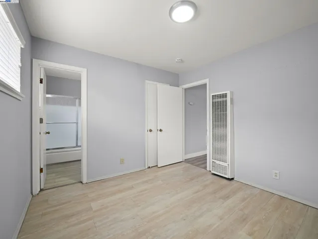 an empty room with closet and wooden door