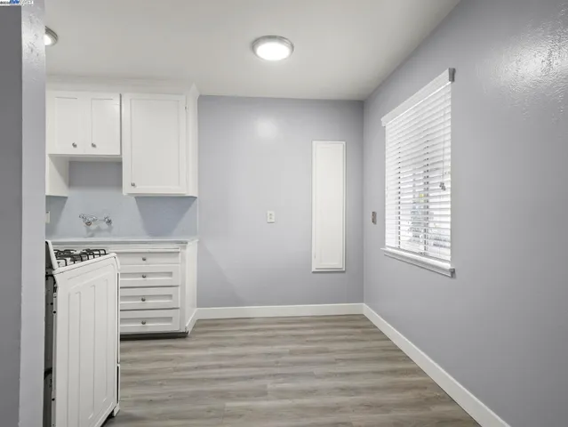 a view of cabinets a wooden floor and a window in a room