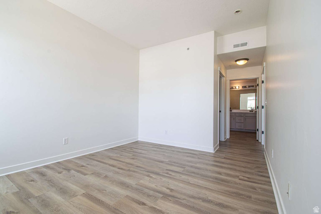 4276 South Main Street, Unit 303 Murray, UT 84107 - Photo 14 of 20 Spacious room featuring wood-finish flooring, white walls, and bright white baseboards