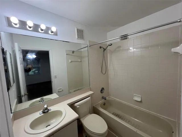 a bathroom with a sink a toilet and shower a mirror