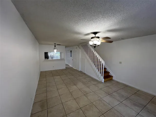 a view of a hallway with entryway and chandelier fan
