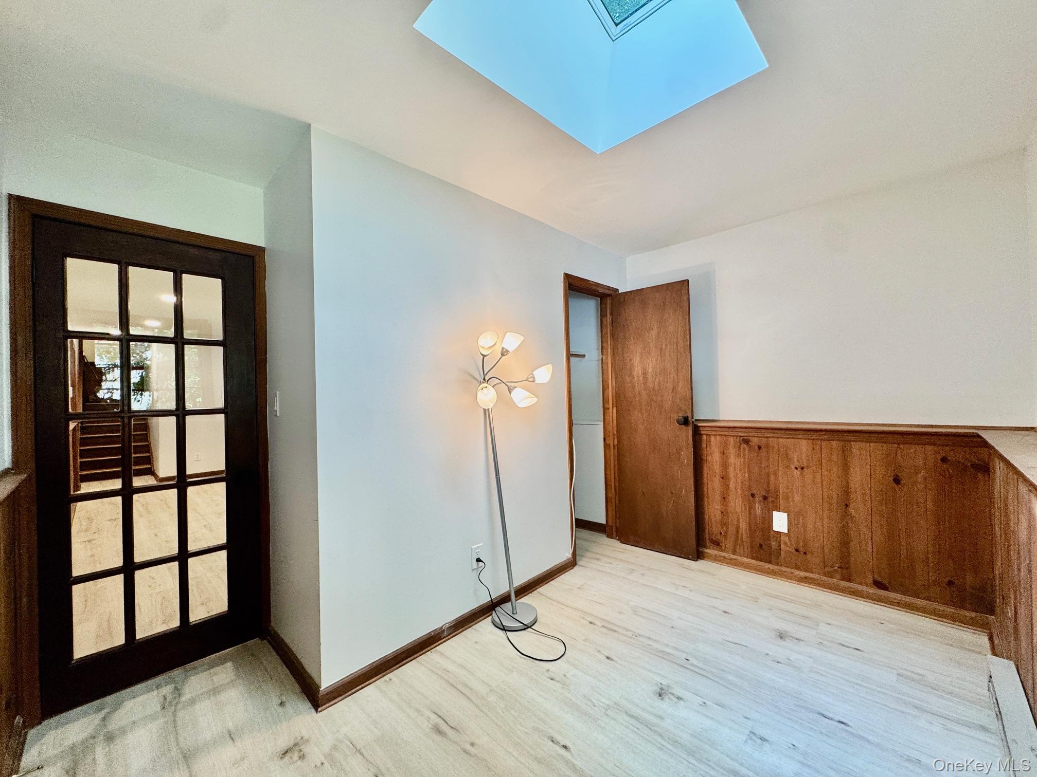687 Sprout Brook Road Putnam Valley, NY 10579 - Photo 28 of 45 an empty room with wooden floor and windows
