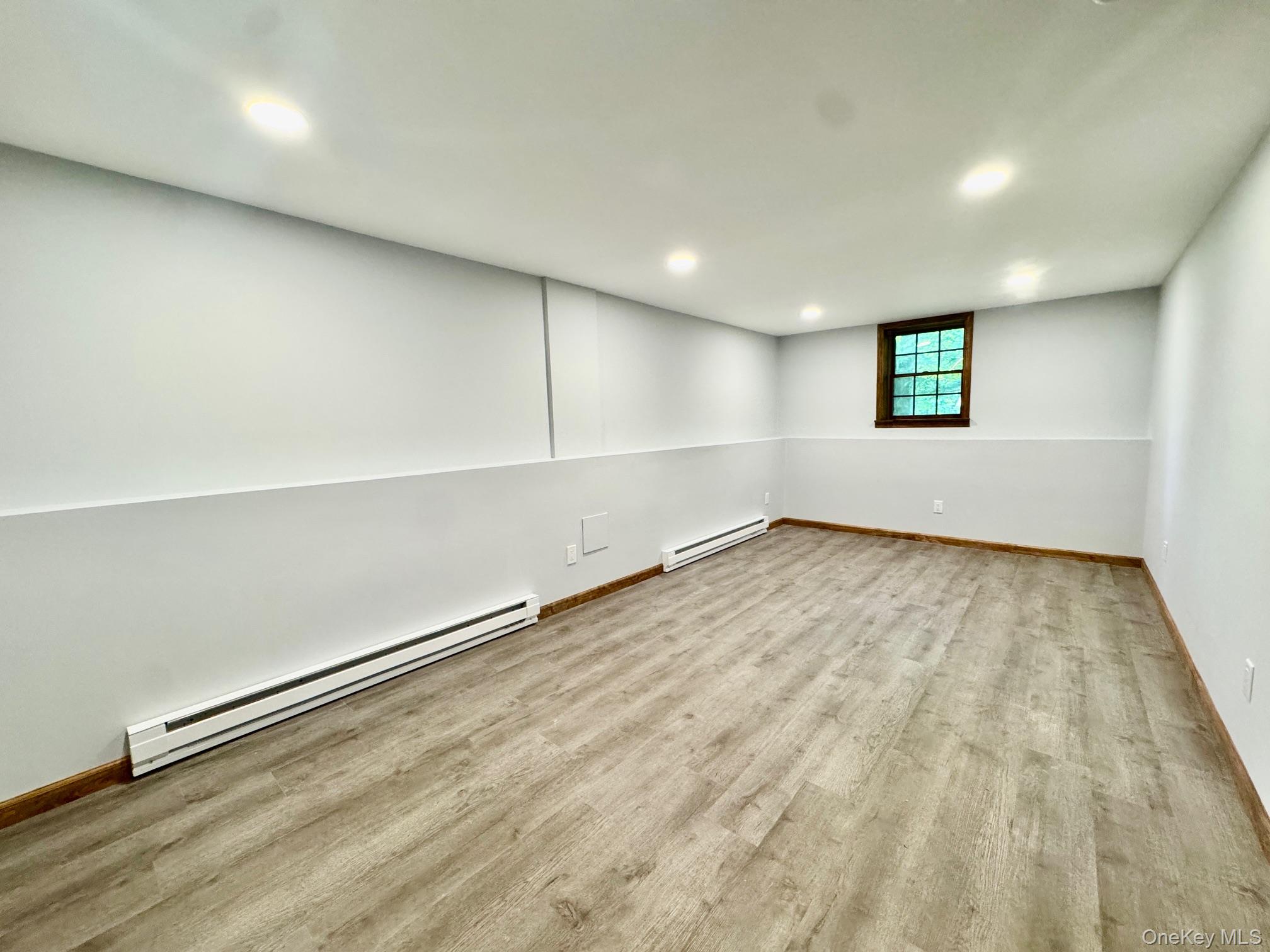 687 Sprout Brook Road Putnam Valley, NY 10579 - Photo 30 of 45 an empty room with wooden floor and windows