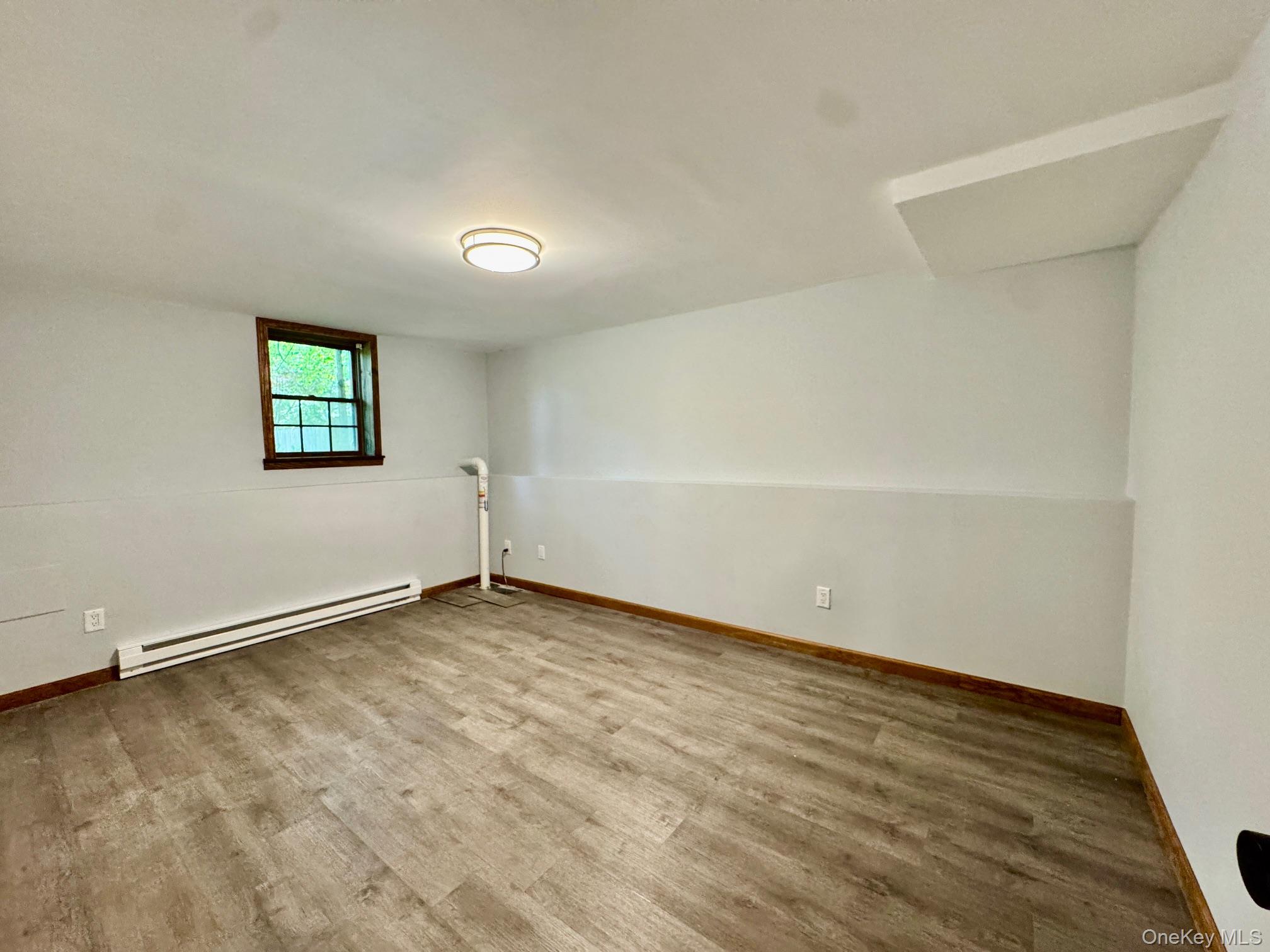 687 Sprout Brook Road Putnam Valley, NY 10579 - Photo 31 of 45 a view of an empty room with wooden floor and a window