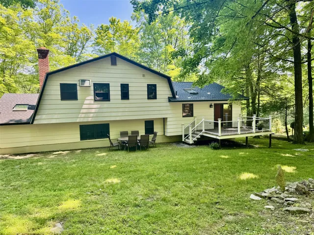 a view of a house with a yard and sitting area