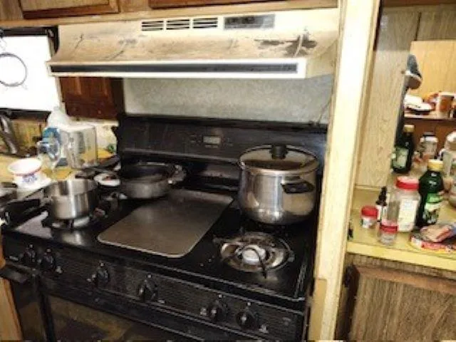 a stove top oven sitting inside of a kitchen