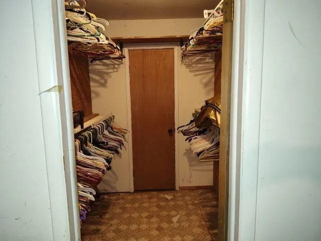a view of walk in closet with clothes