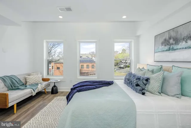 a spacious bedroom with a bed and a lamp