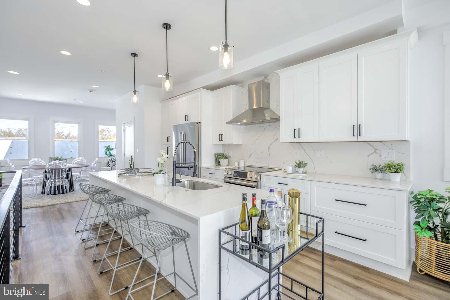 424 Taylor Street Northwest, Unit B Washington, DC 20011 - Photo 4 of 51 a kitchen with stainless steel appliances kitchen island granite countertop a table chairs and a view of living room