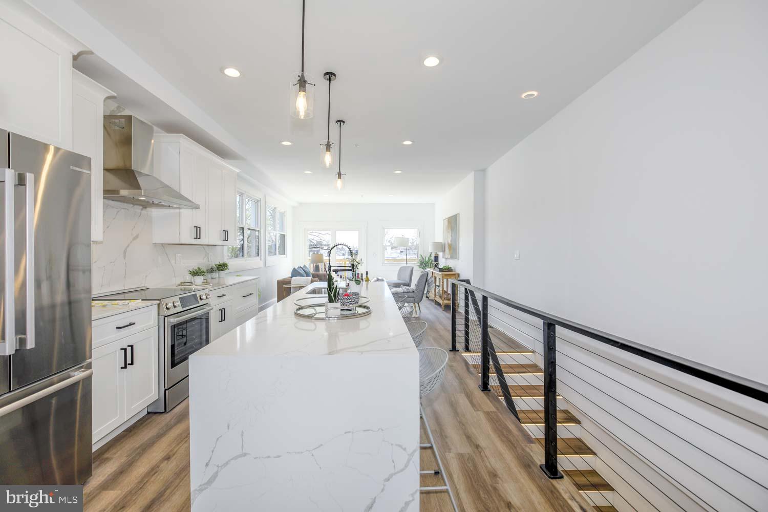 424 Taylor Street Northwest, Unit B Washington, DC 20011 - Photo 5 of 51 a very nice looking open kitchen with stainless steel appliances granite countertop a refrigerator a stove and a sink with wooden floor