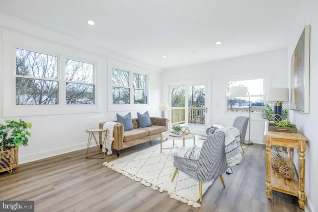 a living room with furniture a wooden floor and a large window
