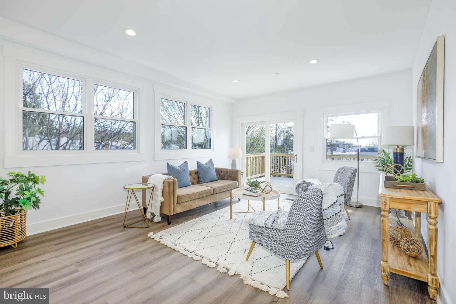 424 Taylor Street Northwest, Unit B Washington, DC 20011 - Photo 8 of 51 a living room with furniture a wooden floor and a large window