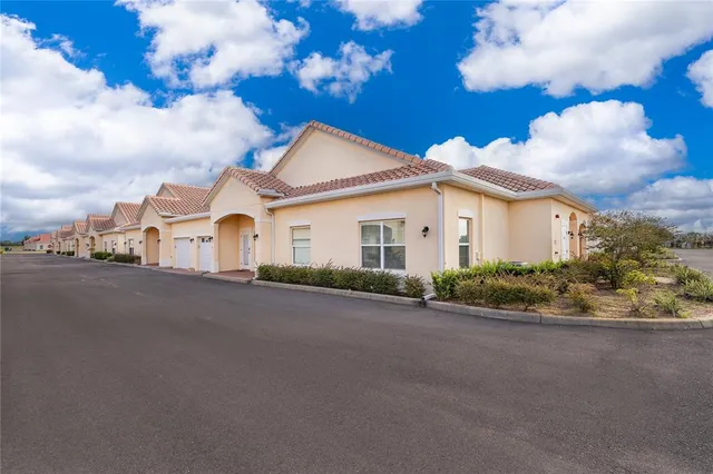 a view of a white house with a yard and garage