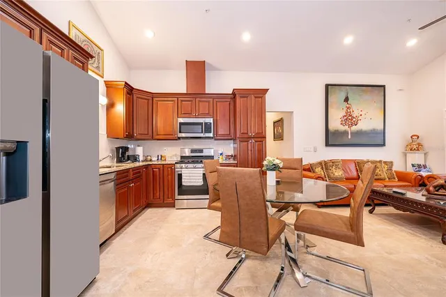a kitchen with stainless steel appliances kitchen island granite countertop a refrigerator and a stove top oven