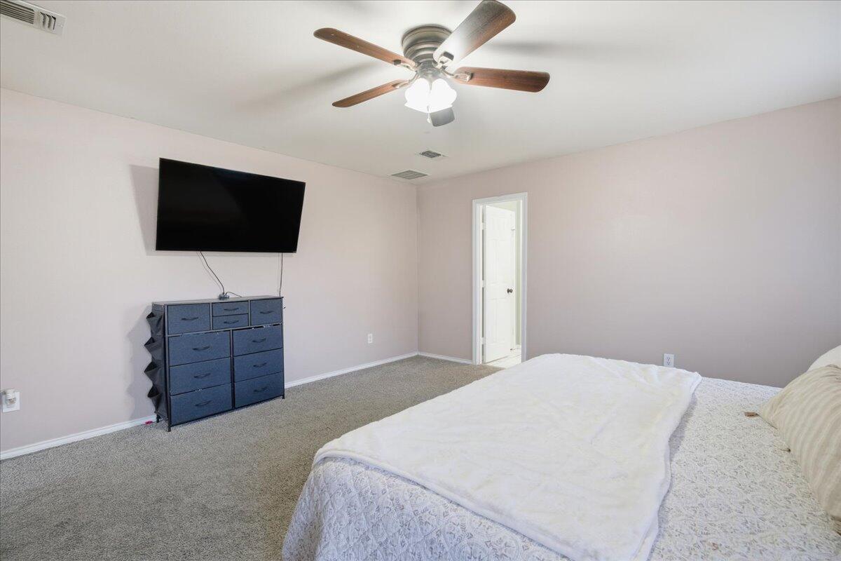 6538 93rd Street Lubbock, TX 79424 - Photo 16 of 27 a bedroom with a bed and a flat screen tv
