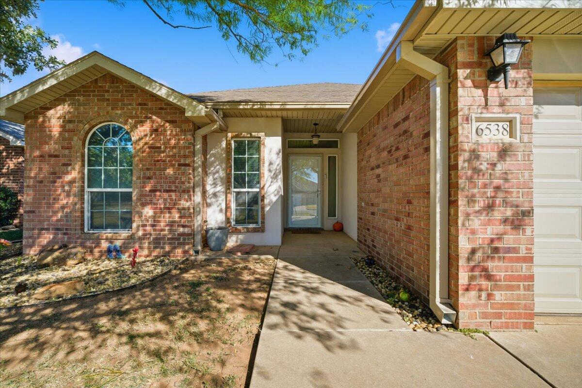 6538 93rd Street Lubbock, TX 79424 - Photo 2 of 27 front view of a brick house with a outdoor space