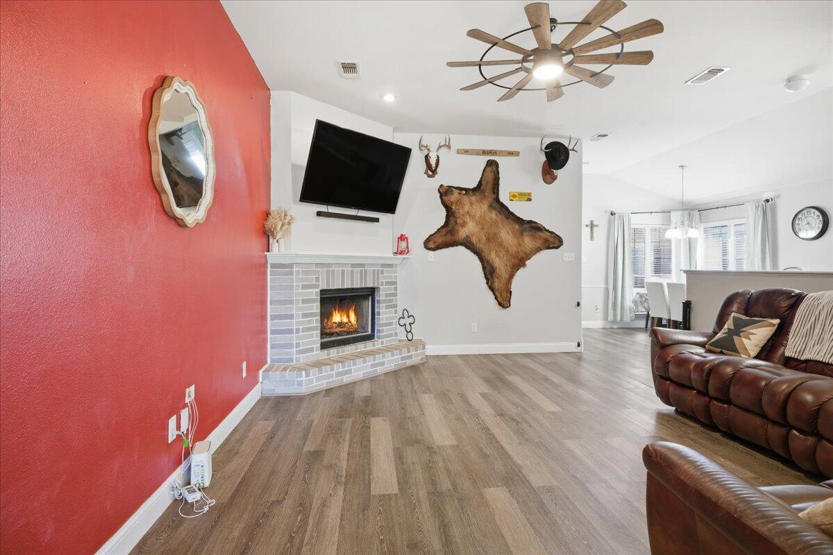 6538 93rd Street Lubbock, TX 79424 - Photo 4 of 27 a living room with furniture a flat screen tv and a fireplace