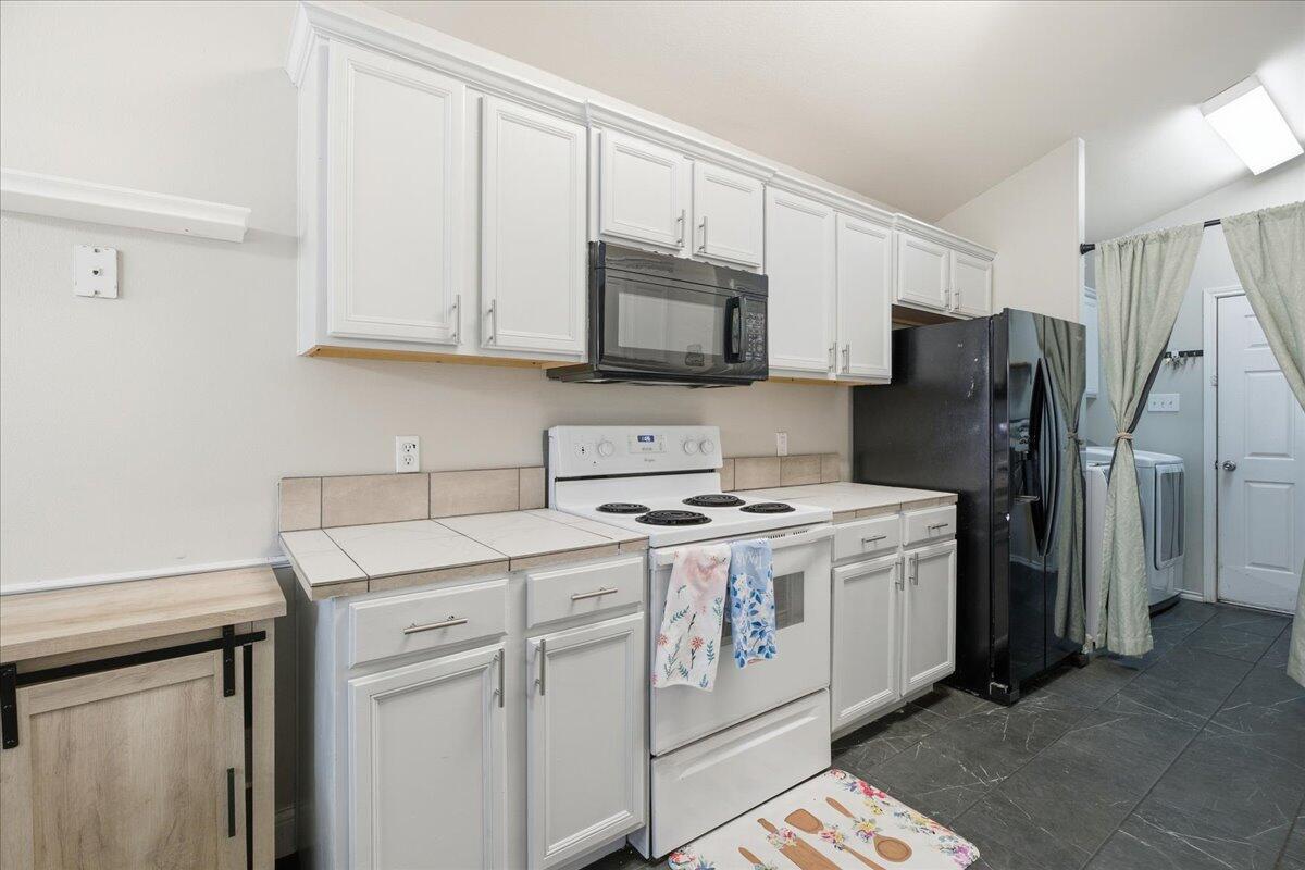6538 93rd Street Lubbock, TX 79424 - Photo 10 of 27 a kitchen with a stove microwave and refrigerator