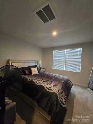 a bed sitting in a bedroom next to a window