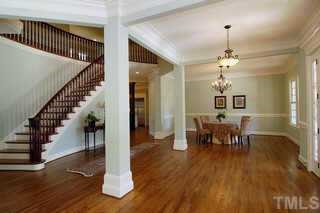 3324 Thomas Road Raleigh, NC 27607 - Photo 3 of 12 a view of a dining room with wooden floor stairs and a chandelier