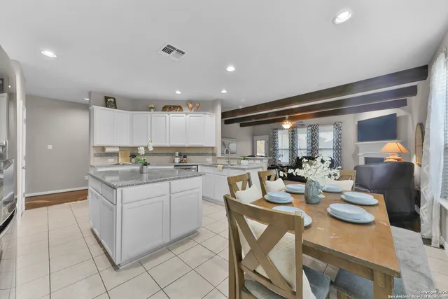 a kitchen with sink refrigerator dining table and chairs