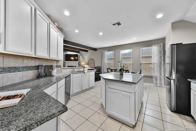 a kitchen with granite countertop a sink stainless steel appliances and cabinets
