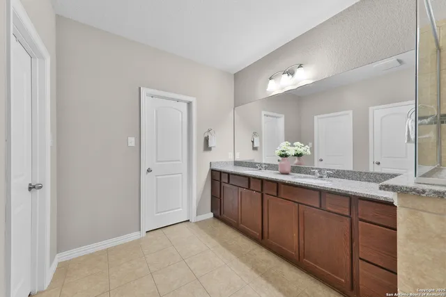 a bathroom with a granite countertop sink and a mirror