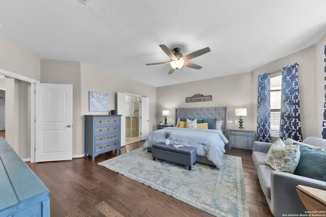 a spacious bedroom with a bed a couch and a chandelier