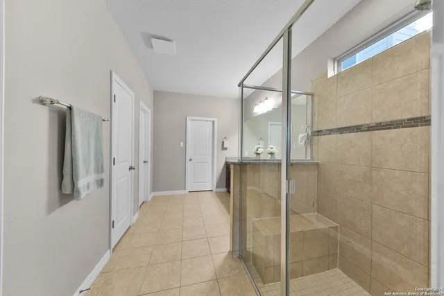 a bathroom with a shower and a glass door