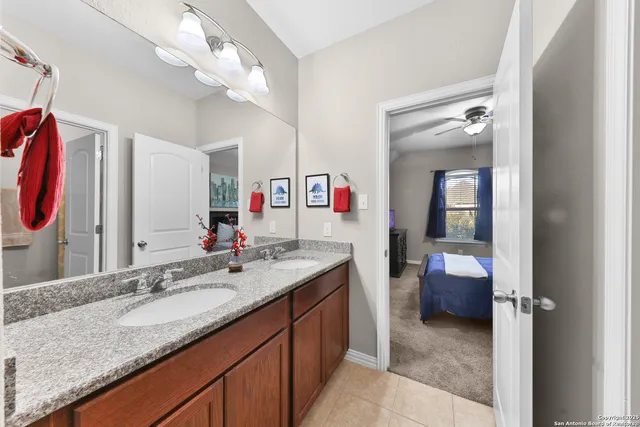 a en suite bathroom with a granite countertop sink and a mirror