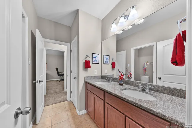 a bathroom with a granite countertop sink and a mirror