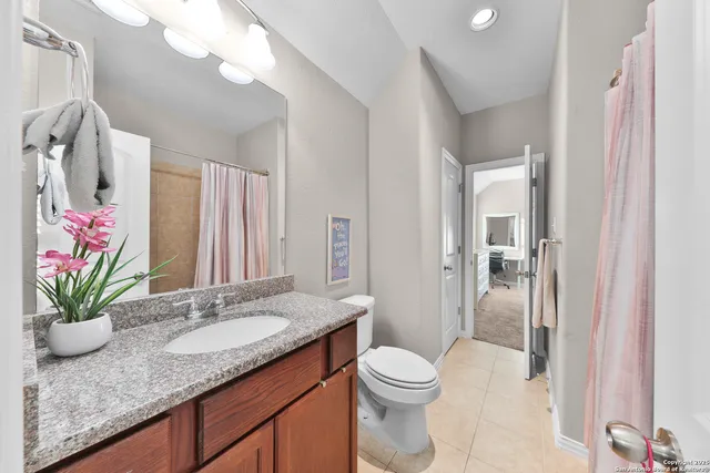 a bathroom with a granite countertop sink a toilet and a mirror