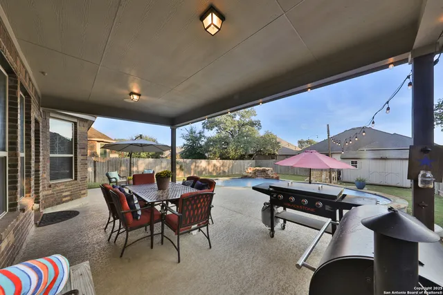 a view of a patio with table and chairs under an umbrella