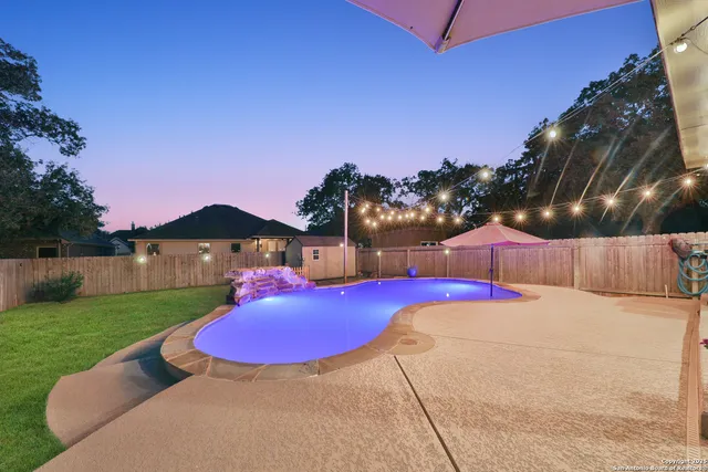 a view of a backyard with a table and chairs under an umbrella